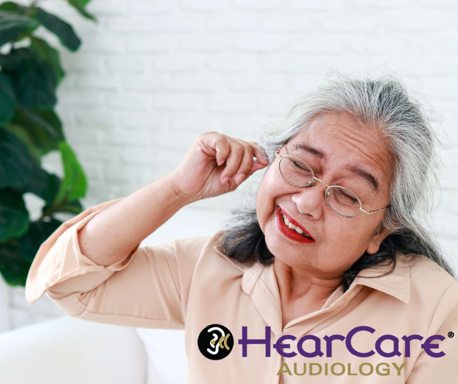 Older woman trying to clean her ear, representing when not to remove earwax at home